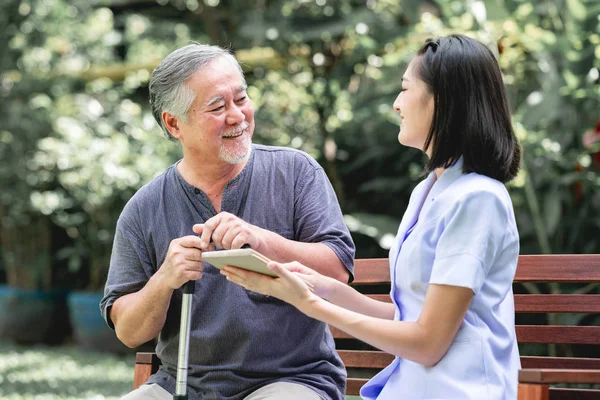 Verpleegkundige Met Patiënt Zittend Bank Samen Kijken Naar Tablet Aziatische — Stockfoto