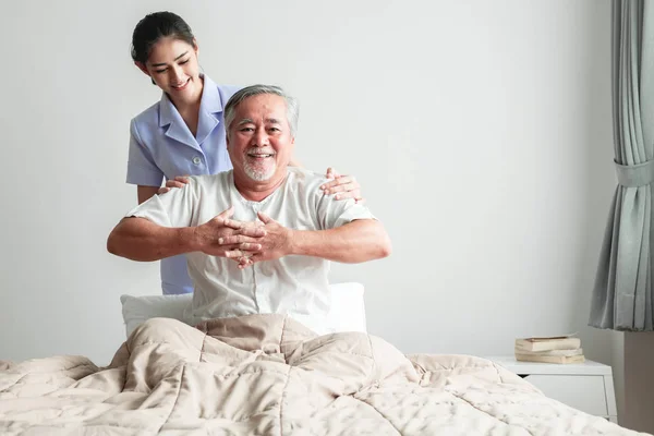 年轻有吸引力的理疗师工作的老人 美丽的亚洲妇女与亚洲老人的背部工作 高级家庭看守服务理念 — 图库照片