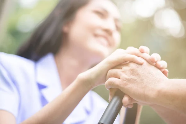 Tröstande Hand Ung Sjuksköterska Innehav Gubbens Hand Utomhus Trädgård Sitter — Stockfoto