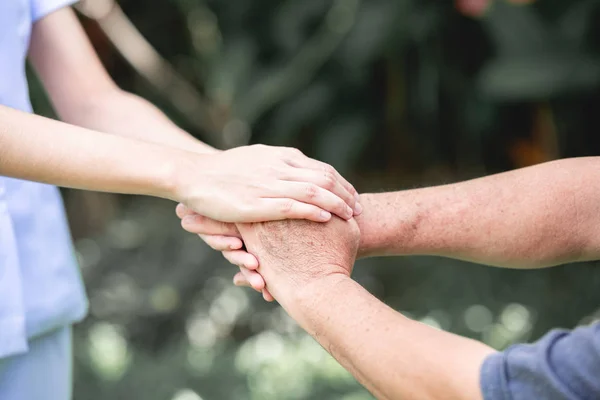 Tröstande Hand Ung Sjuksköterska Innehav Gamla Mans Hand Utomhus Trädgård — Stockfoto