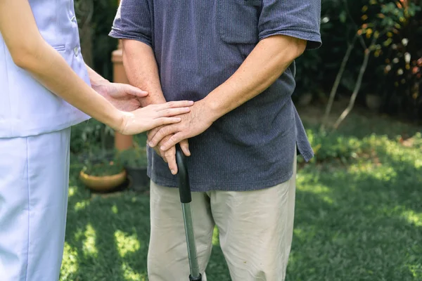 慰めの手 若い看護婦の屋外の庭の保持古い男の手 シニア退職ホーム サービス コンセプト クローズ アップ ショット — ストック写真