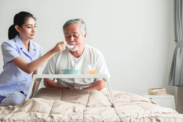 Junge Attraktive Krankenschwester Füttert Einen Älteren Mann Bett Mit Frühstück — Stockfoto