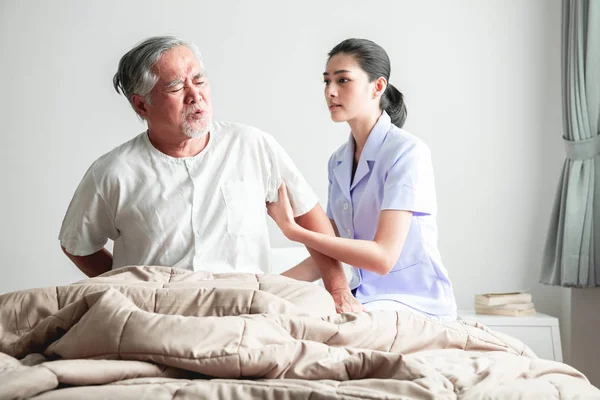 ベッドを取得し 看護師の彼を助けるしようとしている年配の男性 古いアジア人と寝室で開かれたカーテンの美しいアジアの看護師女性 高齢者ホーム サービス コンセプト — ストック写真