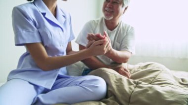 gri saçlı Olgun Asyalı adam elini sıkarken hastanede hemşire