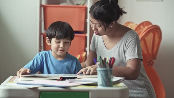 母と息子の家で一緒に本を勉強 — ストック動画