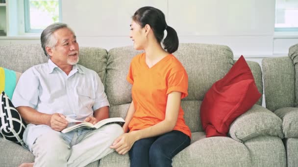 Aziatische Opa Kleindochter Zittend Couch Praten Lezen Van Boek — Stockvideo