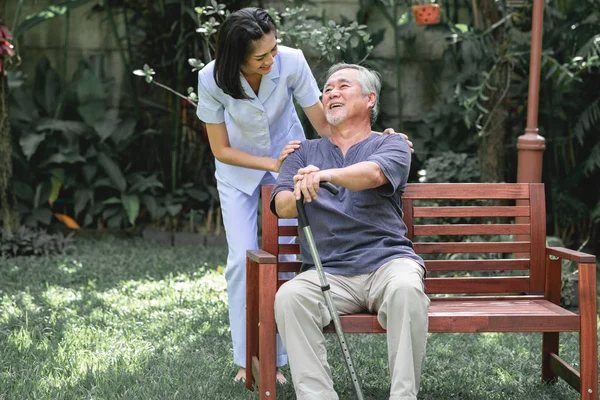 Pielęgniarka Pacjenta Siedzącego Ławce Razem Rozmowa Azjatycka Starszy Pan Siedzi — Zdjęcie stockowe