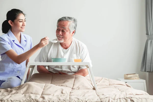 Junge Attraktive Krankenschwester Füttert Einen Älteren Mann Bett Mit Frühstück — Stockfoto