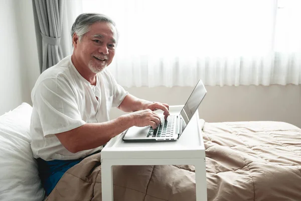Viejo Escribiendo Teclado Cama Senior Asiático Hombre Cama Trabajando Portátil — Foto de Stock