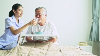 vererek suyu hastanede gri saçlı Asyalı adam olgun hemşire