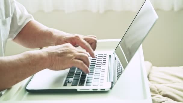Älterer Mann Trägt Weißes Shirt Und Tippt Text Auf Laptop — Stockvideo