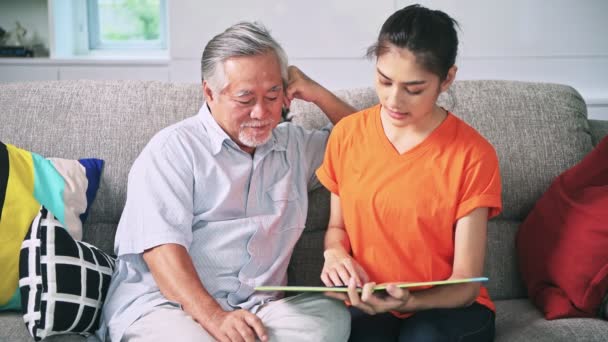 Asiático Abuelo Nieta Sentado Sofá Hablando Leyendo Libro — Vídeos de Stock