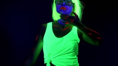 Uv yüz boyama, peruk, parlayan dans giyim, vücut ile güzel seksi kadını vurdu. Beyaz kadın. Parti konsept.