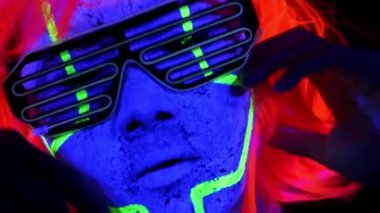 Güzel seksi kadın giyim portre yüz parlayan ile Uv cyborg yüz boyama, peruk, makyaj, yüz dokunmadan el ile kapatın. Asyalı kadın. Parti konsept.