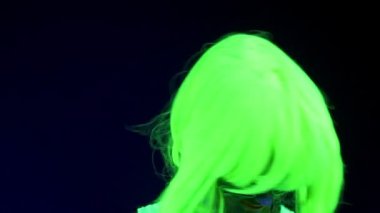 Güzel seksi kadının kafasını sallayarak giyim portre parlayan ile Uv yüz boyama, peruk, yavaş. Beyaz kadın. Parti konsept.