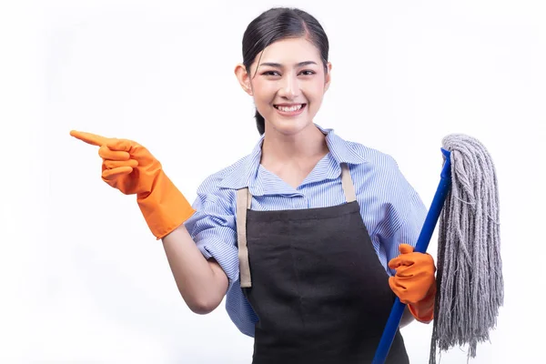 House cleaning service woman isolated in white. Asian young woman with gloves, happy smile, holding a mop, point finger. House cleaning service concept.