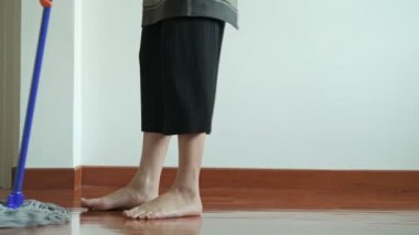 Bir paspas ile temizlik kadın. Güzel Asyalı kadın köpek ısırman çalışın ile paspas ile zemin temizleme. Düşük açılı vurdu. Ev temizlik hizmeti kavramı.