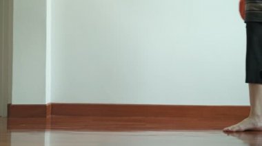 Süpürge ile temizlik kadın. Güzel Asyalı kadın temizlik süpürge ile zemin ve bir köpek onu ısırmaya çalışıyor. Düşük açılı vurdu. Ev temizlik hizmeti kavramı. 