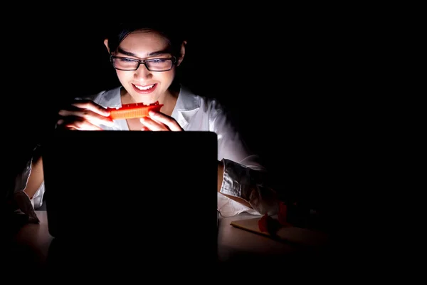 Woman working late at her home office. Beautiful asian woman working on her computer with 3d printer, checking her prototype from 3d printer. Modern start up global business concept.