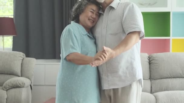 リビング ルームで一緒に踊る年配のカップル 古いアジア男性と女性 ダンス一緒に彼らの家 幸せな笑顔で引退しました シニアのライフ スタイルのコンセプト — ストック動画