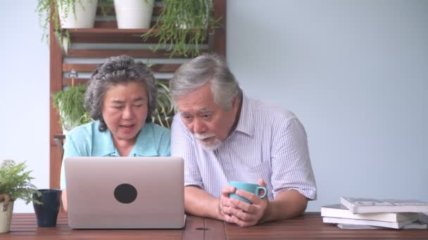 シニア カップル バルコニーでラップトップを使用しようとして座っています 古いアジアの男性と女性 女性の在る彼女の夫を引退したバルコニーの屋外でノート パソコンを使用する方法 シニアのライフ スタイルのコンセプト — ストック動画