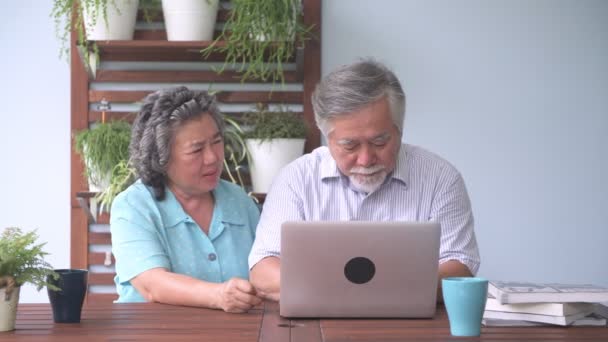 シニア カップル バルコニーでラップトップを使用しようとして座っています 引退した古いアジアの男性と女性 男性在る妻バルコニー屋外でノート パソコンを使用する方法 シニアのライフ スタイルのコンセプト — ストック動画