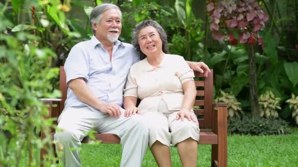 年配のカップルが座っていると 家の庭で一緒に話して 引退した古いアジアの男性と女性 幸せな笑顔 シニアのライフ スタイルのコンセプト — ストック動画