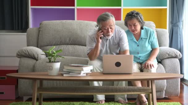 Старшая Пара Сидит Пытается Использовать Ноутбук Гостиной Пенсионерка Мужчина Женщина — стоковое видео