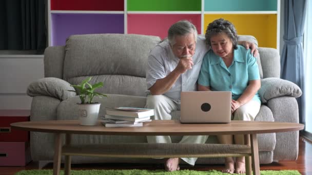 Старшая Пара Сидит Пытается Использовать Ноутбук Гостиной Пенсионерка Мужчина Женщина — стоковое видео