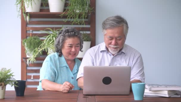シニア カップル バルコニーでラップトップを使用しようとして座っています 引退した古いアジアの男性と女性 混同し バルコニーの屋外 幸せな笑顔でラップトップを使用してください シニアのライフ スタイルのコンセプト — ストック動画
