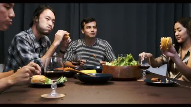 Amigos Cenando Una Fiesta Casa Hombre Asiático Degustando Una Hamburguesa — Vídeos de Stock