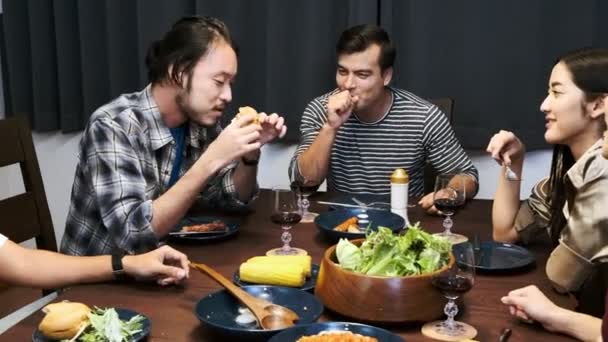 Amigos Cenando Una Fiesta Casa Hombre Asiático Degustando Una Hamburguesa — Vídeo de stock