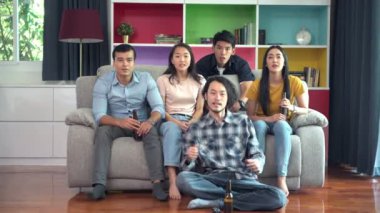 Kanepede birlikte televizyonun arkadaş grubu. Karışık yarış genç insanlar, TV izlerken zevk tezahürat. Ev partisi konsepti.
