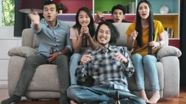 Kanepede birlikte televizyonun arkadaş grubu. Karışık yarış genç insanlar, TV izlerken zevk tezahürat. Ev partisi konsepti.