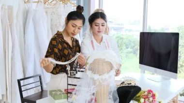Birlikte çalışan genç moda evi tasarımcı. Bir gelinliğin gelin elbise arıyorum genç Asyalı kadın. Küçük işletme kavramı.