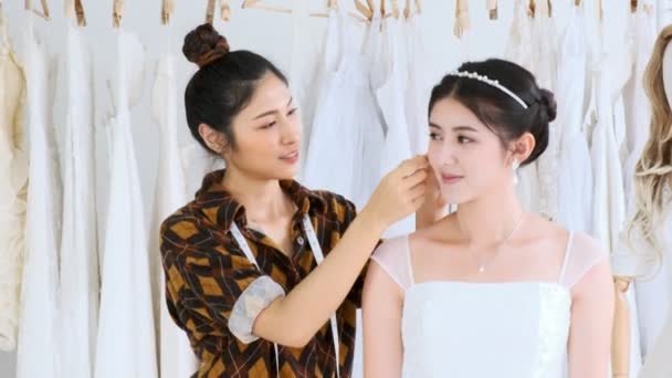 若い結婚式ドレス デザイナー作業 アジアの若い女性は 彼女の顧客の新しいウェディング ドレスを試着をしましょう スモール ビジネス コンセプト — ストック動画