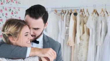 Romantik düğün çift pahalı kıyafet Dükkanı. Beyaz adam ve kadın gelin elbise, birbirimizi tutarak ve öpüşme. Romantik genç çift kavramı.