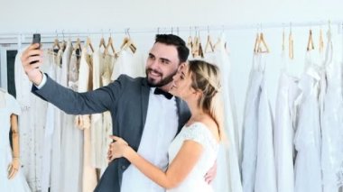 Romantik düğün çift pahalı kıyafet Dükkanı. Beyaz adam ve selfie alarak gelin elbiseli kadın. Romantik genç çift kavramı.