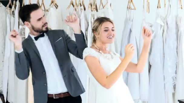 浪漫的一对新婚夫妇在昂贵的服装店 白色的男人和女人穿着新娘的衣服 男人和他的女人一起跳舞 浪漫的年轻夫妇的概念 — 图库视频影像