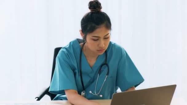 彼女の机の上に座っている若いアジア女性医師は ノート パソコンに患者の検査結果を確認します 若い医師のキャリア概念 — ストック動画