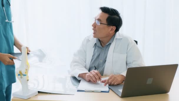 Senior Asian Man Medical Doctor Sitting His Desk Talking Young — Stock Video