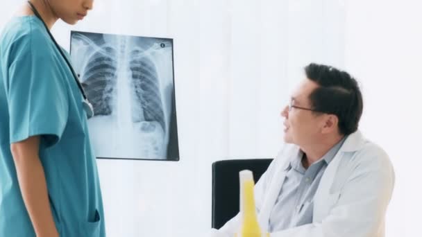 Senior Asian Man Medical Doctor Sitting His Desk Talking Young — Stock Video