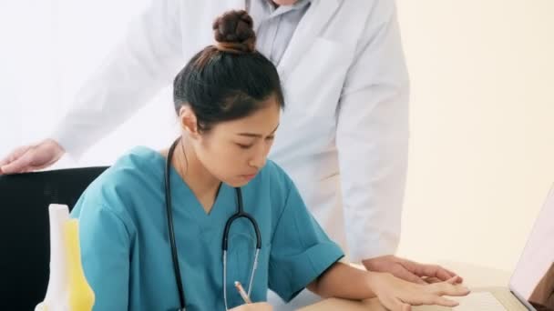 Sénior Asiático Homem Médico Médico Assediando Jovem Médico Mulher Sentado — Vídeo de Stock