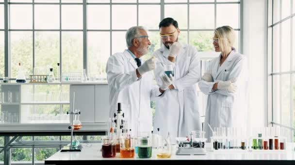 在实验室工作的化学家小组 年轻的白人男性和女性化学家与高级高加索化学家一起在实验室工作 混合化学品 科学理念 — 图库视频影像