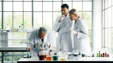 Bir laboratuarda çalışan kimyagerler grubudur. Beyaz genç erkek ve dişi kimyagerler ile mikroskop arıyorum birlikte laboratuarda, çalışan üst düzey beyaz kimyager. Bilim kavramı.