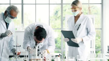 Bir laboratuarda çalışan kimyagerler grubudur. Beyaz genç erkek ve dişi kimyagerler ile mikroskop arıyorum birlikte laboratuarda, çalışan üst düzey beyaz kimyager. Bilim kavramı.