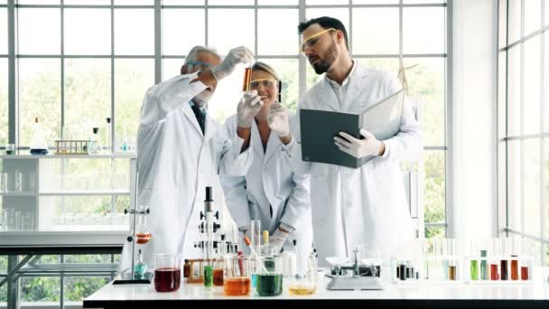 化学実験室での作業のグループ 若い白の化学物質を混合 白人化学を上級演習では 一緒に仕事と男性と女性の化学者 科学のコンセプト — ストック動画