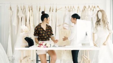 Birlikte çalışan genç moda evi tasarımcı. Bir gelinliğin gelin elbise arıyorum genç Asyalı kadın. Küçük işletme kavramı.