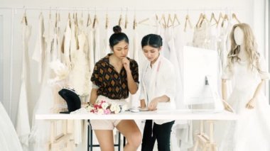 Çalışan genç moda evi tasarımcı. Gelin elbise, Evet ve müşteriler emir alan genç Asyalı kadın ile bilgisayar. Küçük işletme kavramı.