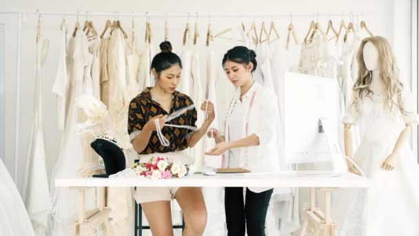 若者のファッション家のデザイナーが一緒に働きます ウェディング ドレスのアクセサリーやネックレスを見て若いアジアの女性 スモール ビジネス コンセプト — ストック動画